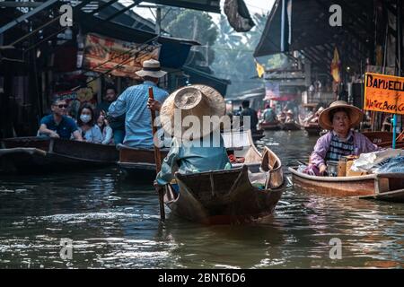Ratchaburi, Damnoen Saduak / Thailand - 11. Februar 2020: Name dieses Ortes Damnoen Saduak Floating Market. Verkäuferin schrubbe das Boot mit ihrem Hut Stockfoto