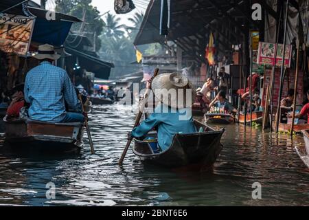 Ratchaburi, Damnoen Saduak / Thailand - 11. Februar 2020: Name dieses Ortes Damnoen Saduak Floating Market. Verkäuferin schrubbe das Boot mit ihrem Hut Stockfoto