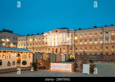 Helsinki, Finnland. Weihnachtsmarkt am Senatsplatz mit Festtagskarussell und Wahrzeichen ist lutherische Kathedrale und Denkmal für russische Kaiser Alexander Stockfoto