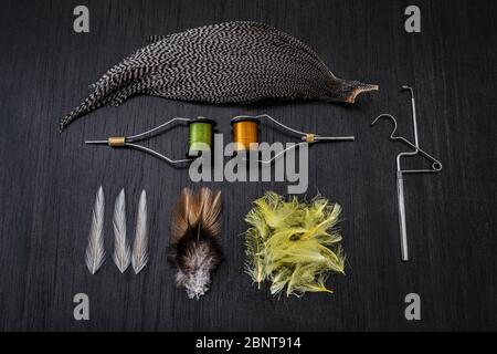 Materialien und Werkzeuge zum Binden von Ködern auf einem Holztisch. Hobby-Konzept Stockfoto