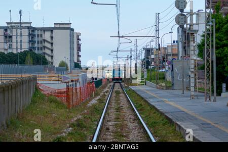 Bild einer leeren Eisenbahnstrecke, die weit weg fährt und in der Ferne Zug Stockfoto