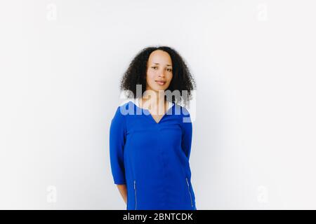 Porträt von fröhlichen schwarzen Frau in blauem Kleid vor weißem Hintergrund Stockfoto