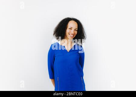 Porträt von fröhlichen schwarzen Frau in blauem Kleid vor weißem Hintergrund Stockfoto