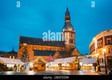 Riga, Lettland - 13. Dezember 2016: Weihnachtsmarkt am Domplatz mit Rigaer Dom. Weihnachtsbaum und Handelshäuser. Wahrzeichen an Wint Stockfoto