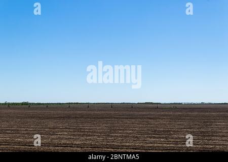 Auf einem Trockenfeld stehende Sprinkler für die Landwirtschaft Bewässerungssystem im Feld. Stockfoto