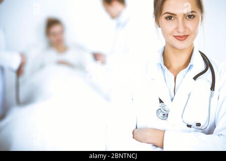 Lächelnd auf den Hintergrund mit Patienten im Bett und zwei Ärzte Ärztin Stockfoto