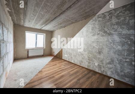 Leeres Zimmer mit großem Kunststofffenster und Heizkörpern vor und nach der Renovierung. Vergleich von alten Zimmer und neu renovierten Platz mit Parkett und grauen Wänden. Konzept der Renovierung des Hauses. Stockfoto