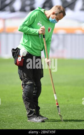 Augsburg, Deutschland. Mai 2020. Fußball: Bundesliga, FC Augsburg - VfL Wolfsburg, 26. Spieltag in der WWK-Arena in Augsburg. Ein Greenkeeper mit Maske bei der Arbeit. WICHTIGER HINWEIS: Gemäß den Bestimmungen der DFL Deutsche Fußball Liga und des DFB Deutscher Fußball-Bund ist es untersagt, im Stadion und/oder aus dem Spiel aufgenommene Fotos in Form von Sequenzbildern und/oder videoähnlichen Fotoserien zu verwenden oder verwendet zu haben. Kredit: Tobias Hase/dpa - Pool/dpa/Alamy Live News Stockfoto