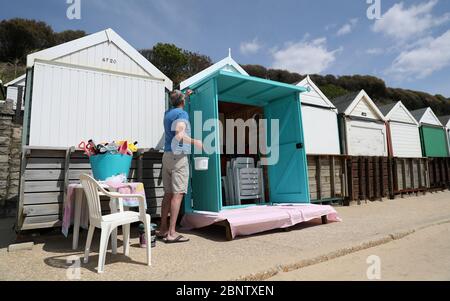 Eine Person malt ihre Strandhütte am Strand von Boscombe in Dorset, nachdem Maßnahmen eingeleitet wurden, um das Land aus der Blockierung zu bringen. Stockfoto