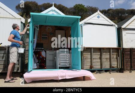 Eine Person malt ihre Strandhütte am Strand von Boscombe in Dorset, nachdem Maßnahmen eingeleitet wurden, um das Land aus der Blockierung zu bringen. PA-Foto. Bilddatum: Samstag, 16. Mai 2020. Siehe PA Geschichte GESUNDHEIT Coronavirus. Das Foto sollte lauten: Andrew Matthews/PA Wire Stockfoto