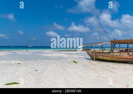 Sansibar, Tansania - 8. Februar. 2020: Holzboot am Strand mit atemberaubendem türkisfarbenem Wasser und Textraum Stockfoto