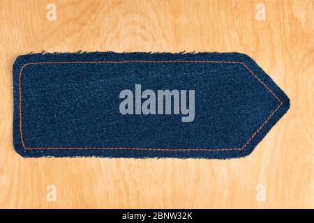 Zeiger aus Denim liegt auf einer Holzfläche. Blick von oben. Leerraum für Text Stockfoto