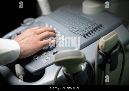 Nahaufnahme eines Technikers, der ein Ultraschallgerät in einer Klinik betreibt. Stockfoto