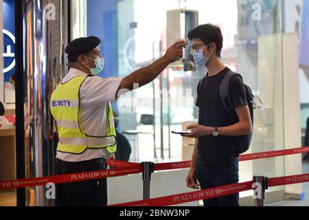 Kuala Lumpur, Malaysia. Mai 2020. Ein Wachmann überprüft die Temperatur eines Käufers in Kuala Lumpur, Malaysia, 16. Mai 2020. Weitere 73 COVID-19 Patienten wurden am vergangenen Tag geheilt und aus dem Krankenhaus in Malaysia entlassen, was die Erholungsrate auf 80.2 Prozent drückte, sagte das Gesundheitsministerium am Samstag. Kredit: Chong Voon Chung/Xinhua/Alamy Live News Stockfoto