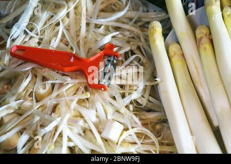 Nahaufnahme des Spargels und seiner Schale und des roten Schneideplechers Stockfoto