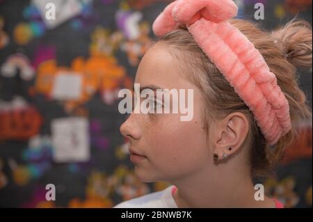 Porträt von schönen braunen Haaren jungen Teenager-Mädchen mit Haselnussfarbe Augen und Sommersprossen auf ihrem Gesicht lacht, lächelt und macht dumme Gesichter zu Hause. Stockfoto