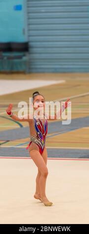 Porträt einer jungen Turnerin. Portrait eines 7 Jahre alten Mädchens bei Wettbewerben der rhythmischen Sportgymnastik Stockfoto