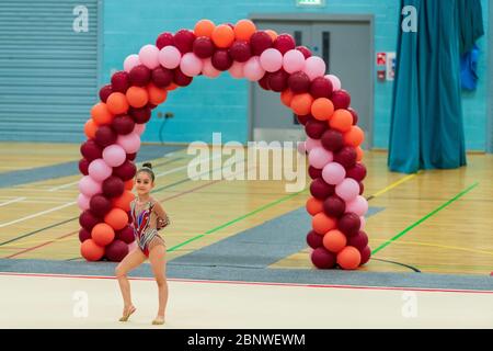 Porträt einer jungen Turnerin. Portrait eines 7 Jahre alten Mädchens bei Wettbewerben der rhythmischen Sportgymnastik Stockfoto