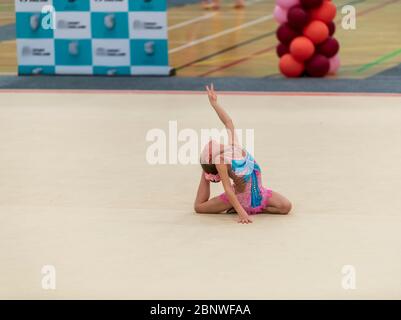 Porträt einer jungen Turnerin. Portrait eines 7 Jahre alten Mädchens bei Wettbewerben der rhythmischen Sportgymnastik Stockfoto