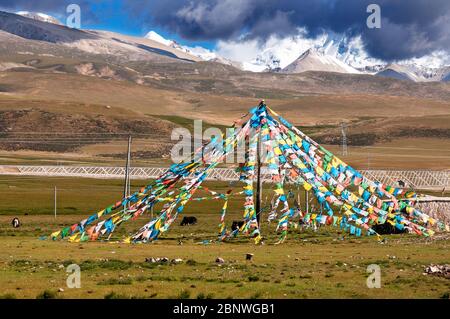 Nyenchen Tonglha Pass. Gebetsfahnen neben dem Fuß des Nyenchen Tanglha 7111 Meter hoch, Tibet China. Einer der heiligen Berge für Tibeter. Stockfoto