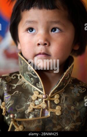 Porträt des jungen tibetischen Jungen in traditioneller Tracht neben Potala Palast Lhasa Tibet China Stockfoto