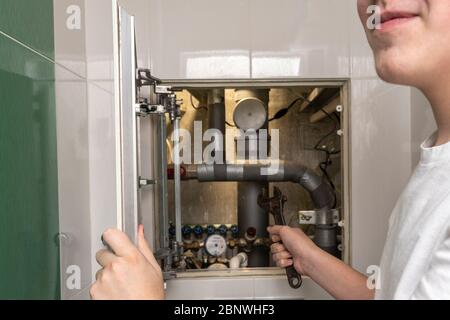 Master Reparatur Sanitär, Reparatur. Sanitär-Schrank. Wasserzähler, Kollektor Wasserdrucksensor Stockfoto