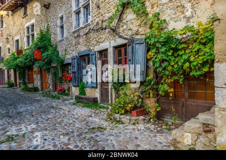 Die Rue des Rondes in Pérouges, einer mittelalterlichen ummauerten Stadt 30 km nordöstlich von Lyon, hat den Status eines der schönsten Dörfer Frankreichs verliehen. Stockfoto