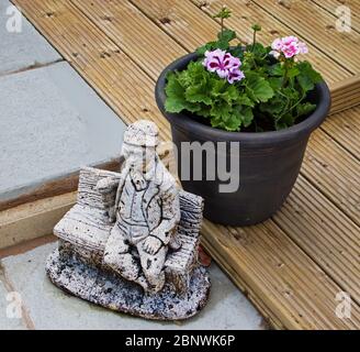 Ein Garten-Einstellung, mit einem Feature Ornament setzen einen Pflanzentopf auf Pflaster und Deck Stockfoto