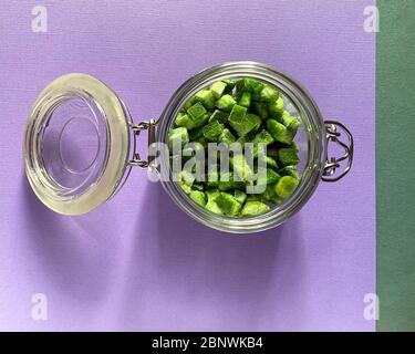 Nahaufnahme eines köstlichen Bio roh getrockneten Pomelo, kandierte Früchte in einem schönen Glas, getrocknete Pomelo auf lila Hintergrund. Draufsicht Stockfoto