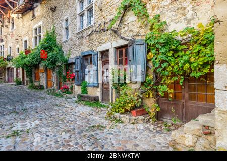 Die Rue des Rondes in Pérouges, einer mittelalterlichen ummauerten Stadt 30 km nordöstlich von Lyon, hat den Status eines der schönsten Dörfer Frankreichs verliehen. Stockfoto