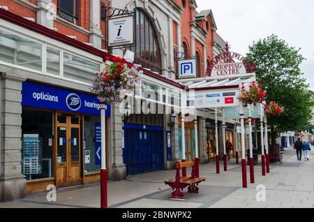 Llandudno, Großbritannien: 27. Aug 2019: Eine allgemeine Straßenszene in der Mostyn Street, die den Eingang zu einem Einkaufszentrum und einer Filiale von Boots-Optikern zeigt. Gesehen h Stockfoto