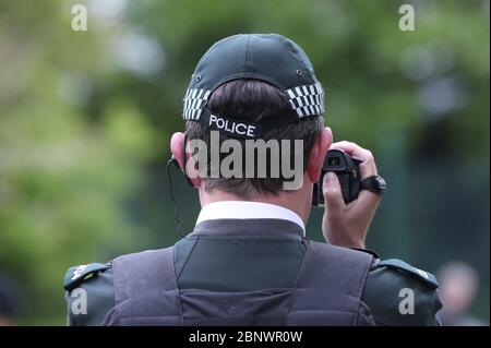 Ein PSNI-Offizier überwacht die Anti-Covid-19-Beschränkungen, die Demonstranten bei einer Versammlung im Ormeau Park, Belfast, nach der Einführung von Maßnahmen, um das Land aus der Blockade zu bringen. Stockfoto