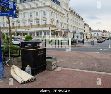 Llandudno, UK: 27. Aug 2019: Ein zusammengerollter Teppich wird neben einem Mülltonnen auf der Promenade des Badeortes Llandudno abgestellt. Stockfoto