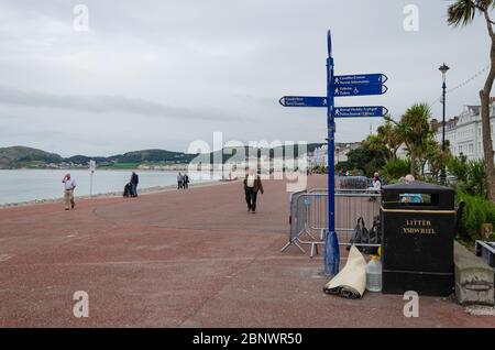 Llandudno, UK: 27. Aug 2019: Ein zusammengerollter Teppich wird neben einem Mülltonnen auf der Promenade des Badeortes Llandudno abgestellt. Stockfoto