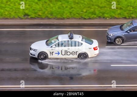 Weißer PKW Uber Taxi fährt auf der Autobahn Luftaufnahme. Russland, Sankt Petersburg. 15. Mai 2020 Stockfoto