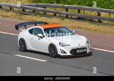 2012 weißer Toyota GT86 D-4s mit ausgefahrenem Spoiler; UK Vehicular Traffic, Straßentransport, moderne Fahrzeuge, Limousinen, Fahren von Fahrzeugen, Straßen und Motoren, Fahren in Richtung Süden auf der Autobahn M61 Stockfoto