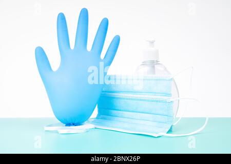 Aufgeblasene Nitril Einweg-Handschuh mit einer schützenden medizinischen Maske und einer Plastikflasche antibakterielles Handdesinfektionsgel - ein Virenschutz Stockfoto