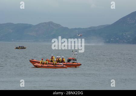 Das Rettungsboot Atlantic 85 Beaumaris trifft auf die kleinere 'D' Klasse, während HM Coastguard Hubschrauber in der Ferne übt. Juni 2018 Stockfoto