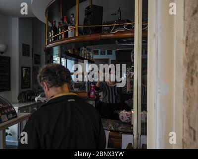 Cremona, Lombardei Italien, Mai 2020 - Barkeeper Frau in Café-Bar im Stadtzentrum langsam öffnen und Getränke nur zu gehen und einige übliche Kunden retu Stockfoto