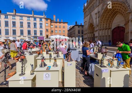 Lyon, Frankreich: Ein geschäftiges Kunst- und Keramikmarkt am Place Saint-Jean bei der Kathedrale von Lyon (Cathédrale Saint-Jean-Baptiste), einer römisch-katholischen Kirche. Stockfoto