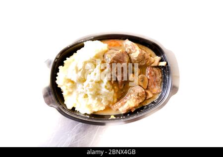 Plastikbehälter mit Rinderpüree und Pilzsauce Stockfoto