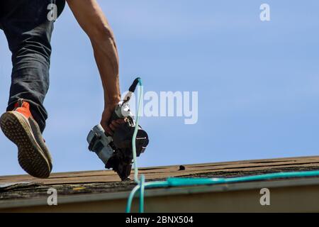 Dachdecker, die an der Erneuerung des Hauses arbeiten, installierten neue Schindeln Stockfoto