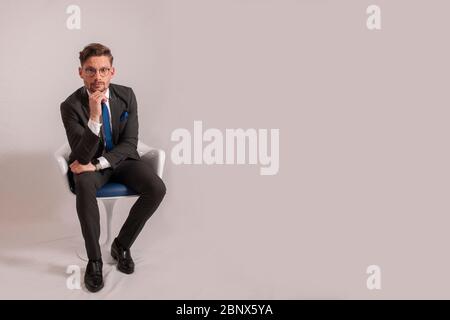 Junger Geschäftsmann sitzt auf einem Stuhl Stockfoto