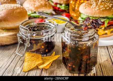 Hausgemachte Speck Marmelade in Gläsern, mit Brot und Burger Stockfoto