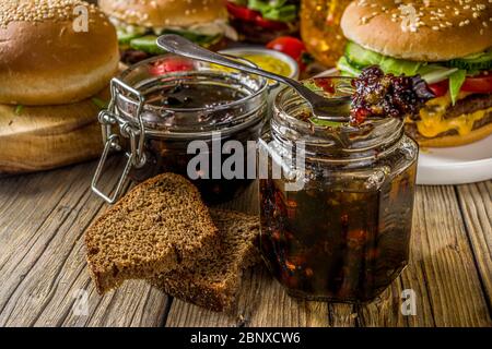 Hausgemachte Speck Marmelade in Gläsern, mit Brot und Burger Stockfoto