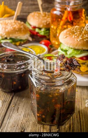 Hausgemachte Speck Marmelade in Gläsern, mit Brot und Burger Stockfoto