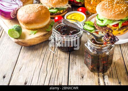 Hausgemachte Speck Marmelade in Gläsern, mit Brot und Burger Stockfoto