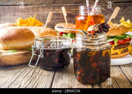 Hausgemachte Speck Marmelade in Gläsern, mit Brot und Burger Stockfoto