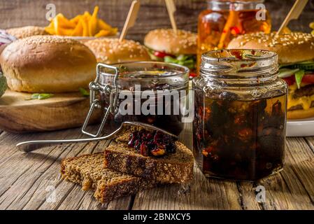 Hausgemachte Speck Marmelade in Gläsern, mit Brot und Burger Stockfoto