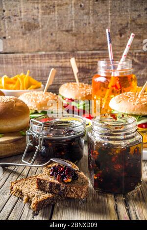 Hausgemachte Speck Marmelade in Gläsern, mit Brot und Burger Stockfoto